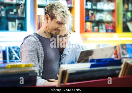 Coppia giovane scegliendo Vintage LP in vinile in record Shop Foto Stock