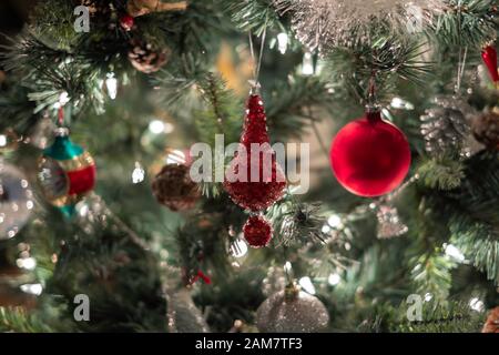 Primo piano di un albero di Natale illuminato con il rosso e ornamenti in argento le luci di Natale. Foto Stock