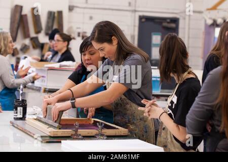 Artista Brittany Houk (sinistra) guide un sostenitore fare stampe al Pratt Fine Arts Center di Sabato, 11 gennaio 2020. Guidato da artista Claire Jauregui per il quarto anno consecutivo, i membri del pubblico sono stati invitati a schermata Help Stampare manifesti da artisti locali a sostegno della prossima Womxn del marzo a Seattle. Schermo di seta disegni sono stati forniti da artisti Eileen Jimenez, Lynda Sherman e Leigh Riibe. Il rally e marzo, organizzato da Seattle Womxn marciare in avanti, si terrà il 18 gennaio 2020. Foto Stock