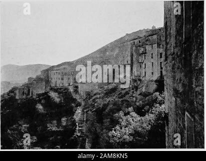 Romantica Corsica, vagabondare nell'isola di Napoleone; . architettura taliana su di loro, anche se theeffect è un po 'viziato dalla pietra nera con cui la maggior parte delle case sono costruite. Nello spazioso mercato-luogo si torna alla vita idilliaca e di questo corso - l'eterno politicaldiscussioni, il saunter sulla terrazza della chiesa, da cui si può ottenere una vista veramente meravigliosa del surroundingcountry, il dolce farniente pervaso in cui il corso è un tale adepto. Butpicturesque Sart^ne non è sempre stato così pacifico.La sua storia è tragica. E dintorni il t Foto Stock