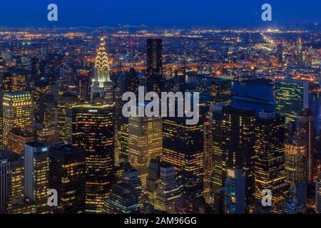 Veduta aerea del tramonto dei grattacieli iconici di New York Midtown Manhattan e dello skyline di Long Island con luci della città Foto Stock