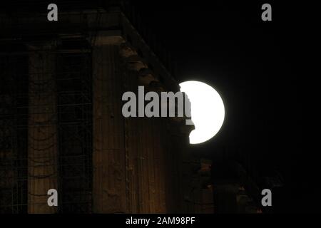 La luna del lupo sorge sopra il tempio del Partenone, nell'Acropoli. La prima luna piena del 2020, conosciuta anche come la "luna del lupo", coincide con un'eclissi lunare. Foto Stock