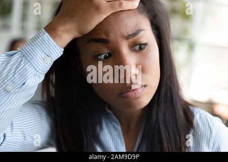 Faccia di closeup la donna africana ritiene sollecitata avere problemi sul lavoro Foto Stock