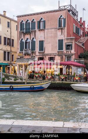 Venezia, ITALIA - 29 ottobre 2019: Prime luci artificiali su tavoli all'aperto sul canale di Cannaregio fiancheggiato da vecchie case pittoresche, sparato il mese di ottobre Foto Stock