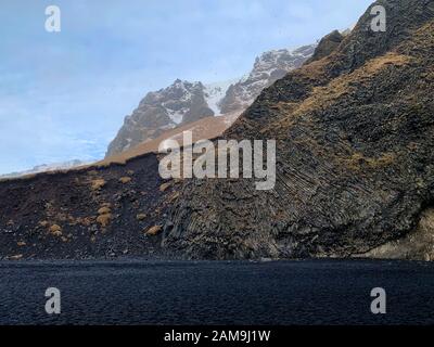 Colonne basaltiche create quando la lava si indurisce, spiaggia vulcanica nera di Vik , comune di Mýrdalshreppur, Islanda meridionale Foto Stock