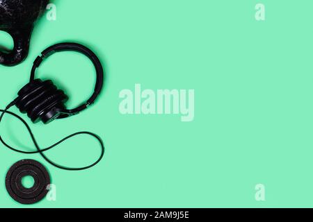 Foto sportive. Kettlebells e manubri di menta su sfondo verde. Appartamento laico, vista dall'alto, copia dello spazio. Foto Stock