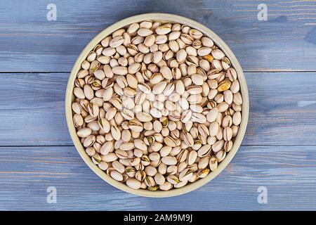 Pistacchi su sfondo ligneo. Pistacchi salati arrosto. Foto Stock