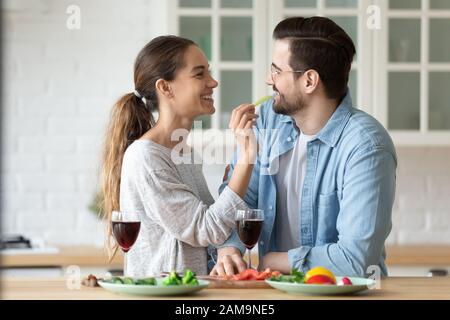 Allegro giovane razza mista donna alimentare amato uomo verdure. Foto Stock