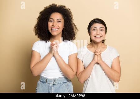 Le donne americane indiane e africane che si levano in piedi con la mano unita. Foto Stock