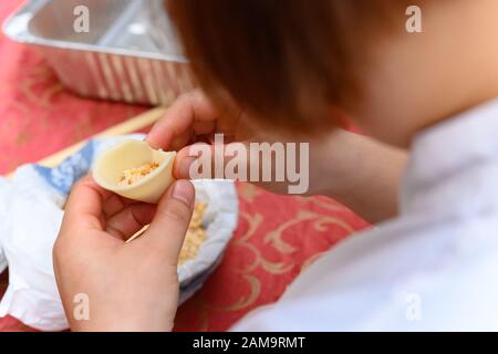 Lady Making tradizionale cinese Yau Kok Zai o dolce gnocco per il Capodanno cinese Foto Stock