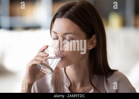 Una giovane donna sana beve acqua minerale pura Foto Stock