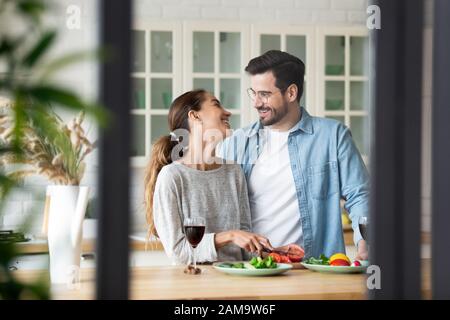 Felice misto gara ragazza chattando con il ragazzo, preparando cena romantica. Foto Stock