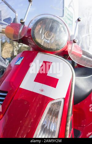 Primo piano di un piatto a L su uno scooter Vespa Piaggio rosso Foto Stock