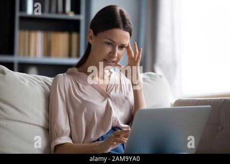 Donna confusa frustrata dai problemi di malfunzionamento del computer Foto Stock