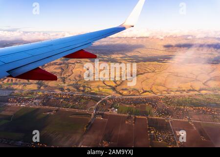 Volare sopra la contea di Santa Clara vicino al tramonto, autostrada 101 visibile alla base delle colline; campi agricoli visibili in primo piano; San Jose Foto Stock