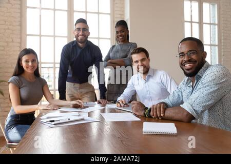 I dipendenti multietnici sorridenti si riuniscono in riunioni consiliari Foto Stock