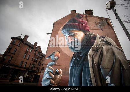 Uno dei murales più noti di Glasgow, per Slug artista di strada, raffigura un moderno St Mungo che fa riferimento alla storia dell'uccello Che Non Volò Mai. Il 13 gennaio è la festa di San Mungo che è il santo patrono e fondatore della città di Glasgow. Foto Stock