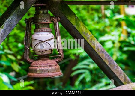 primo piano di una vecchia lanterna rustica d'epoca con la giungla sullo sfondo Foto Stock