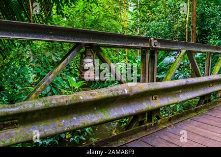 Vecchia lanterna rustica d'epoca su un ponte in un paesaggio della giungla, architettura in natura Foto Stock