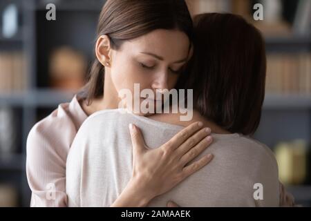 Triste adulto mamma e figlia abbracciano dopo la lotta Foto Stock
