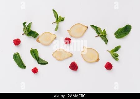 Piatto di foglie di menta, lamponi e fette di radice di zenzero. Vista dall'alto Foto Stock