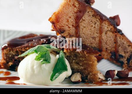 Fetta di torta al cioccolato con gelato alla vaniglia, caramello e menta. Gourmet placcatura di delizioso deserto. Foto Stock