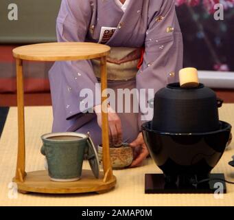 Cerimonia del tè giapponese Chanoyu. Donna vestita con kimono tradizionale sussurra il tè con chasen. Foto Stock