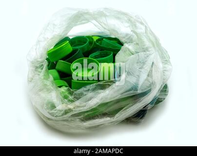Tappi per bottiglie in plastica verde ordinati per colori in sacchetti di plastica monouso trasparenti. PP un inquinamento PET. Soluzioni per il riciclaggio dei rifiuti in plastica. Foto Stock