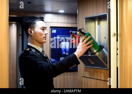 (200112) -- HEFEI, 12 gennaio 2020 (Xinhua) -- il membro dell'equipaggio del treno Liu Hengduo controlla gli estintori sul treno G24 da Hefei della provincia di Anhui della Cina orientale a Pechino, 12 gennaio 2020. Un gruppo di giovani dipendenti della squadra di treno della sezione Hefei di China Railway Shanghai Group Co., Ltd. Ha debuttato recentemente durante la corsa di corsa di primavera Festival. Cinque dei sei membri di questa squadra sono nati nel 2000. Il 12 gennaio, il team post-2000s ha iniziato il proprio lavoro durante la più grande migrazione annuale del paese sul treno G24 da Hefei a Pechino. (Foto Di Zhou Mu/Xinhua) Foto Stock