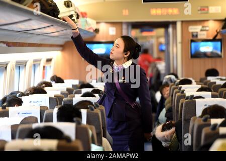 (200112) -- HEFEI, 12 gennaio 2020 (Xinhua) -- il membro dell'equipaggio del treno Wang Yuxin organizza i bagagli sul treno G24 dalla provincia di Hefei dell'Anhui della Cina orientale a Pechino, 12 gennaio 2020. Un gruppo di giovani dipendenti della squadra di treno della sezione Hefei di China Railway Shanghai Group Co., Ltd. Ha debuttato recentemente durante la corsa di corsa di primavera Festival. Cinque dei sei membri di questa squadra sono nati nel 2000. Il 12 gennaio, il team post-2000s ha iniziato il proprio lavoro durante la più grande migrazione annuale del paese sul treno G24 da Hefei a Pechino. (Foto Di Zhou Mu/Xinhua) Foto Stock