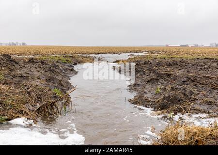Gennaio tempeste con heavy rain causato allagamenti in campi di fattoria, traboccante di fossati e di erosione del suolo dal fluire acqua runoff Foto Stock