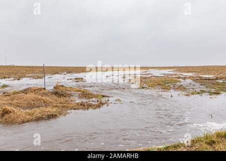 Gennaio tempeste con heavy rain causato allagamenti in campi di fattoria, traboccante di fossati e di erosione del suolo dal fluire acqua runoff Foto Stock