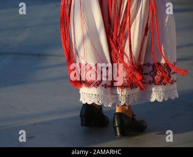 I ballerini professionisti del Timisul Folklore Ensemble tengono le mani in una danza tradizionale rumena indossando costumi tradizionali belli. Foto Stock