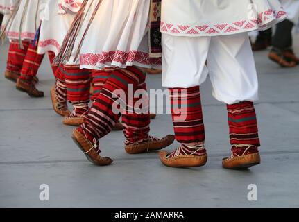 I ballerini professionisti del Timisul Folklore Ensemble tengono le mani in una danza tradizionale rumena indossando costumi tradizionali belli. Foto Stock