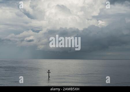 Una classica immagine minimalista di mare, orizzonte e nuvola in un momento nel tempo catturato in una bella luce Foto Stock