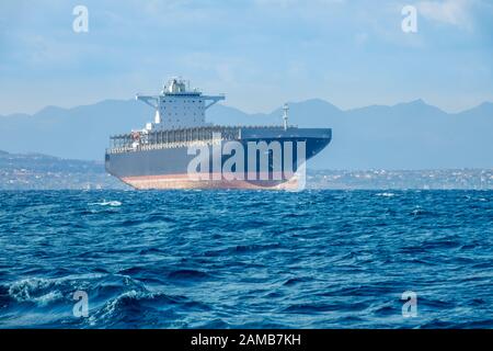 Giornata estiva soleggiata e mare calmo. Nave da carico vuota vicino alla costa mediterranea Foto Stock
