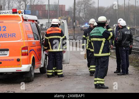 Amburgo, Germania. 12th Gen 2020. I servizi di emergenza che indossano maschere respiratorie sono distribuiti nell'area portuale lungo una linea ferroviaria. Una perdita in un contenitore con fusti di acido aveva provocato un'operazione importante da parte dei vigili del fuoco di Amburgo. Durante un controllo di routine su un treno merci nel porto, è stato notato il gocciolamento di acido dal contenitore, ha detto un portavoce del reparto antincendio. Il contenitore è stato prelevato dal carro presso il Terminal Container Altenwerder e aperto. Credito: Bodo Marks/Dpa/Alamy Live News Foto Stock