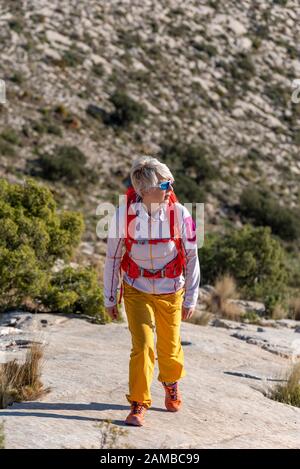 Donna escursioni lungo ridgecrest passeggiate su collina, El Divino montagna, provincia di Alicante, Costa Blanca, Spagna Foto Stock