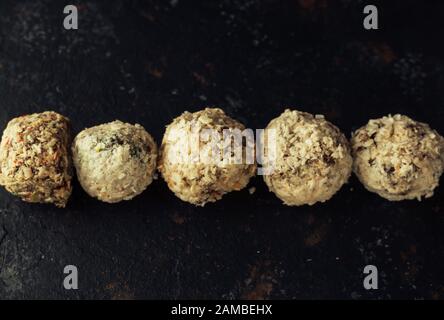 Bulbi di energia cruda con cocco su sfondo scuro. Immagine orizzontale, spazio di copia, vista dall'alto. Foto Stock