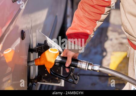 Il personale della stazione di benzina sta pompando combustibile per un automobile. Foto Stock