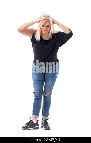 Giocoso affascinante bella età di mezza frustrato donna che si scompigliano e tira i capelli. Corpo intero isolato su sfondo bianco. Foto Stock