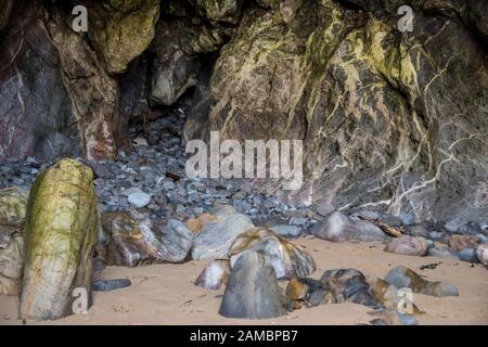 Dettaglio delle rocce e dei ciottoli raccolti sul retro di una piccola grotta presso La Three Cliffs Bay, La penisola di Gower, Galles Foto Stock