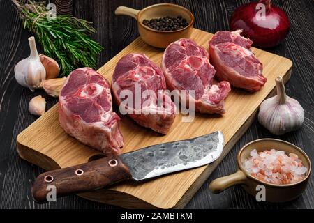 Bistecca di agnello fresco tritata su tagliere con spezie Foto Stock