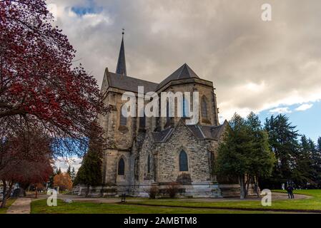 Bariloche, ARGENTINA, 18 GIUGNO 2019: Percorso colorato con alberi rossi accanto alla cattedrale di Nuestra Senora del Nahuel Huapi. Foto Stock