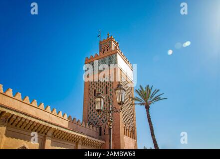 Torre di minareto moschea nel quartiere medina di Marrakech, Marocco. Ci sono pareti e palme. E' un palazzo Badi. Foto Stock