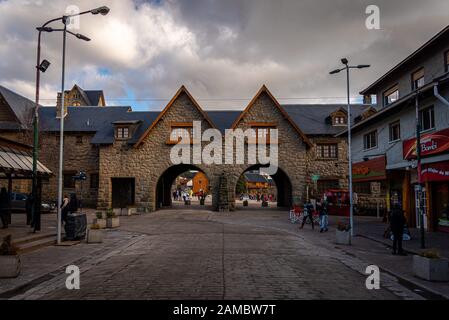 BARILOCHE, ARGENTINA, 18 GIUGNO 2019: Vista del centro civico e del municipio attraverso la galleria di pietra, mentre la gente passa. Foto Stock