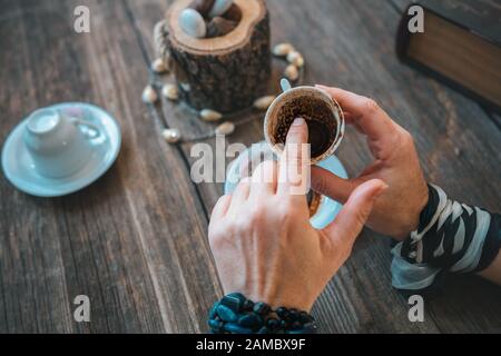 donna tenere la tazza e raccontare fortuna con tradizionale tazza di caffè turco Foto Stock