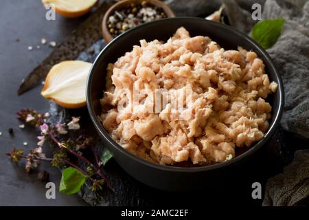 Carne macinata e ingredienti per cucinare carne macinata in una ciotola su un ardesia. Foto Stock