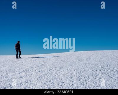 Donna escursionista su un ghiacciaio con ramponi su stivali Foto Stock