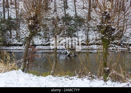 Nevoso salice e stagno in inverno e alimentatori per anatre e riflessione Foto Stock